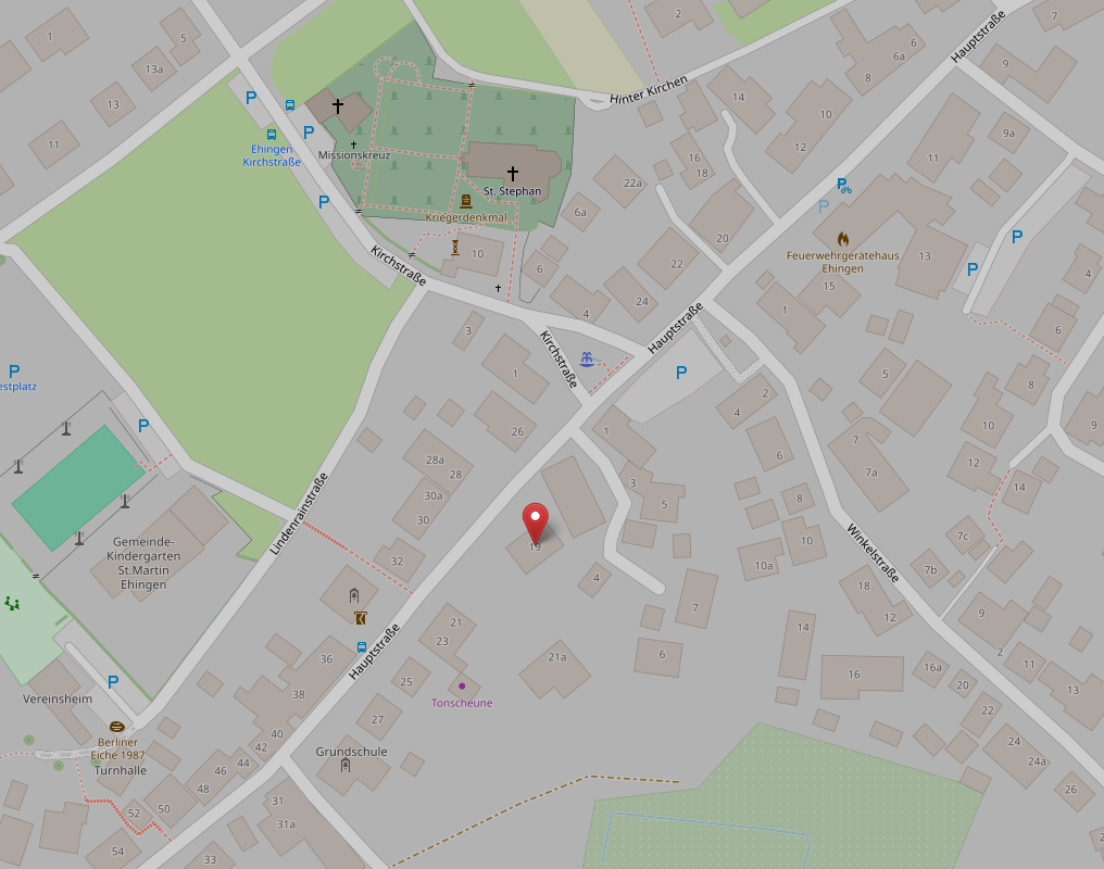 Karte eines Wohngebiets mit Straßen, Gebäuden, Parkplätzen, einer Kirche St. Stephan, einem Kindergarten St. Martin, einer Grundschule und einem roten Standortmarker.